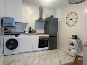 een keuken met een koelkast en een wasmachine bij Apartamento Cueto II in Soto del Barco