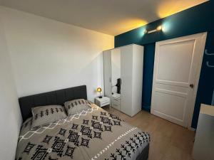 - une chambre avec un lit et un mur blanc et bleu dans l'établissement La Recouvrance-centre ville-wifi, à Niort