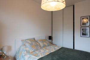 - une chambre avec un lit et un lustre dans l'établissement Haven of peace near Paris, à Asnières-sur-Seine