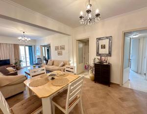 a living room with a table and a dining room at Elli & Klairi Apartment in Ágios Rókkos