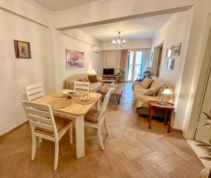 a dining room and living room with a table and chairs at Elli & Klairi Apartment in Ágios Rókkos