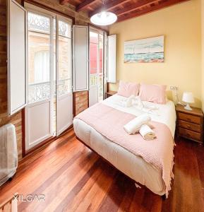 ein Schlafzimmer mit einem großen Bett und zwei Fenstern in der Unterkunft Casa VeiraMar in Pobra do Caramiñal