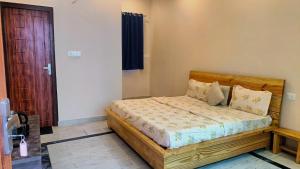 a bedroom with a bed with a wooden headboard at Kalakriti Homestay in Rishīkesh