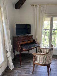 a piano in a room with a chair next to a window at BORGO VILLA VALENTINI in Scandiano