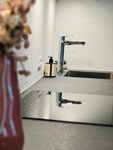 a bathroom mirror with a soap dispenser on a sink at The Old Hotel Silkeborg - 1MTH in Silkeborg