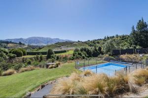 a swimming pool in the middle of a grassy field at Rakaia Gorge Views - Mt Hutt in Windwhistle
