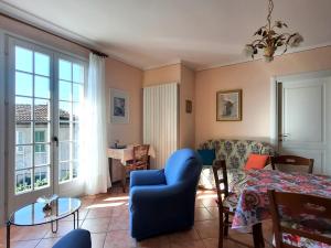 a living room with a blue chair and a table at Appartamento Porto 2 in Cannero Riviera
