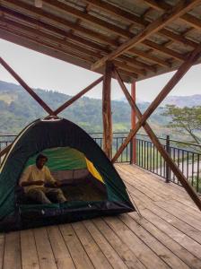 DeltotaにあるDeltota Lake View Campingの櫓のテントに座る男
