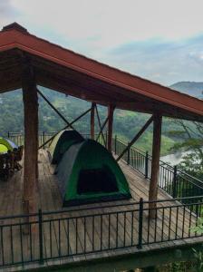 a tent on a deck with a view of a river at Deltota Lake View Camping in Deltota