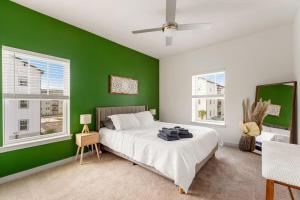 a green bedroom with a bed and two windows at Cozy 2Bed Boho Hideaway 10 Min to Parks Allows Pet in Orlando