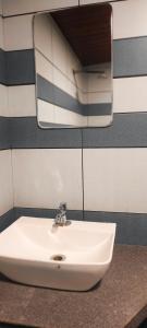 lavabo blanco en el baño con espejo en ANGELSNESTMOUNTAINVIEW, en Chegāt