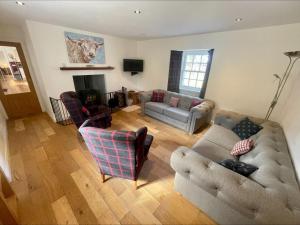 sala de estar con 2 sofás y chimenea en Sherrabeg Cottage, en Newtonmore