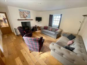 a living room with two couches and a fireplace at Sherrabeg Cottage in Newtonmore