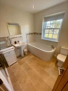a bathroom with a tub and a sink and a toilet at Sherrabeg Cottage in Newtonmore
