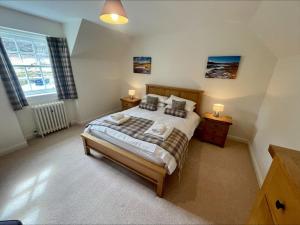 a bedroom with a large bed and two night stands at Sherrabeg Cottage in Newtonmore
