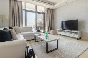 a living room with a couch and a tv at Frank Porter - The 8 in Dubai