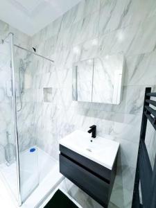 a white bathroom with a sink and a shower at Modern Luxury 2 Bed with Parking in Catford