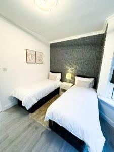 a bedroom with two beds and a window at Modern Luxury 2 Bed with Parking in Catford