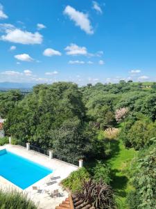 een afbeelding van een zwembad met stoelen en bomen bij Las Barrancas in San Lorenzo