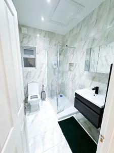 ein Bad mit einer Dusche, einem Waschbecken und einem WC in der Unterkunft Modern Luxury 2 Bed with Parking in Catford