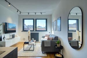uma sala de estar com um sofá e um espelho em Canal Couture: Navigli Luxury Retreat em Milão