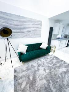 a living room with a green couch and a rug at Modern Luxury 2 Bed with Parking in Catford