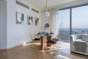 a living room with a table and chairs and a couch at Frank Porter - Boulevard Point in Dubai