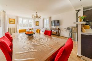 uma sala de jantar com uma grande mesa de madeira e cadeiras vermelhas em Spacious nest in the heart of Flassans-sur-Issole em Flassans-sur-Issole
