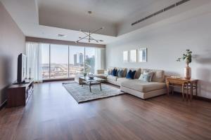 a living room with a couch and a tv at Frank Porter - Emirates Crown Tower in Dubai