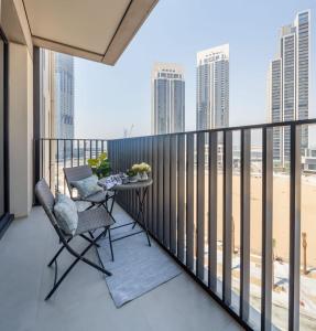 a balcony with two chairs and a table with a view of the beach at Frank Porter - Creek Horizon T1 in Dubai