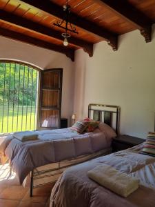 twee bedden in een kamer met een groot raam bij Las Barrancas in San Lorenzo