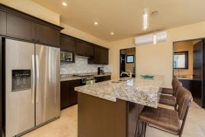 a kitchen with a stainless steel refrigerator and a counter at Spacious New 3BR Villa at Copala-Quivira in Cabo San Lucas