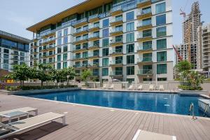 uma piscina em frente a um grande edifício em Frank Porter - Sobha Hartland Greens em Dubai