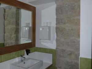 a bathroom with a sink and a mirror at Hotel El Cerco in Puente la Reina