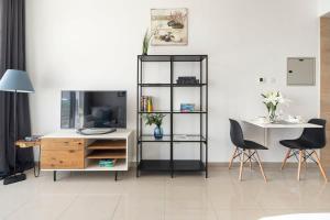 a living room with a tv and a desk and chairs at Frank Porter - Siraj Tower in Dubai