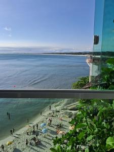 a view of a beach from a window at Pousada Marambaia Café in Barra de Guaratiba