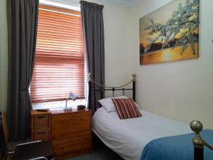 Schlafzimmer mit einem Bett und einem Fenster in der Unterkunft Phoenix Guest House in Blackpool