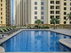 a large swimming pool with buildings in the background at Frank Porter - Bahar 1 in Dubai