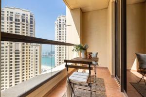 a balcony with a table and a view of the ocean at Frank Porter - Bahar 1 in Dubai