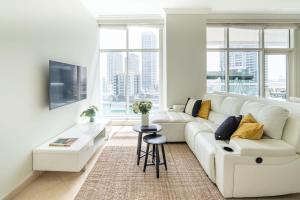 a white living room with a couch and a table at Frank Porter - Dorra Bay in Dubai