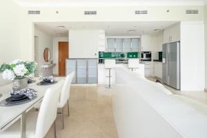 a large white kitchen with white tables and white chairs at Frank Porter - Dorra Bay in Dubai
