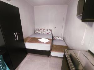 a small small room with two beds in it at Casa Container Azul Mariscal in Bombinhas
