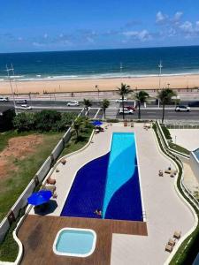 an overhead view of a swimming pool and the beach at UNU Armação in Salvador