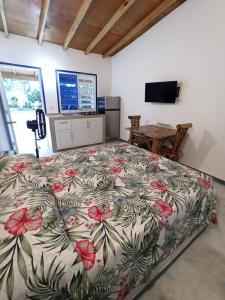 a bedroom with a large bed with a floral bedspread at El Bucanero in Las Terrenas