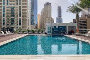 a large swimming pool in a city with tall buildings at Frank Porter - Botanica Tower in Dubai