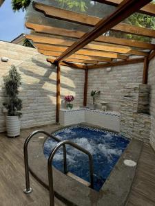 un patio con bañera de hidromasaje y techo de madera en Casa Colibrí., en Manta