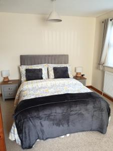 a bedroom with a large bed with two night stands at Cosy Pembrokeshire Home in Pembrokeshire