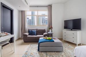 sala de estar con sofá y TV en Frank Porter - Yacht Bay en Dubái