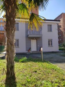 a palm tree in front of a white house at Grigio Perla Panigale, villetta con giardino e parcheggio privato gratuito in Bologna