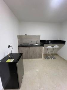 a kitchen with a counter and two stools in a room at Apto 301 cerca a C.C. unicentro in Cúcuta